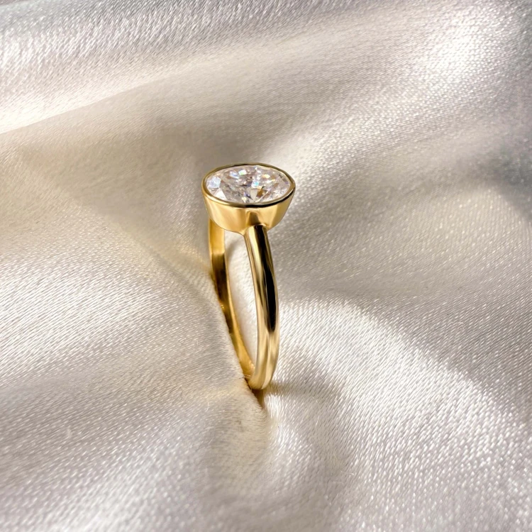 verlobungsring-bezel-moissanit-0-5ct-ovalschliff-nahaufnahme-seite-gelbgold-pure-hariets.jpg