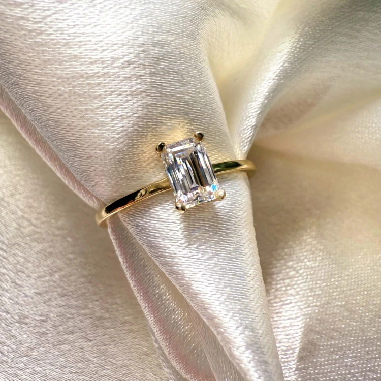 verlobungsring-petit-moissanit-0-5ct-smaragdschliff-nahaufnahme-gelbgold-finesse-hariets.jpg