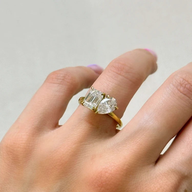 verlobungsring-toi-et-moi-moissanit-3-5ct-emeraldschliff-birnschliff-am-finger-nahaufnahme-gelbgold-gemini-hariets.jpg
