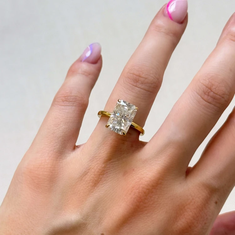 verlobungsring-royal-stones-moissanit-5ct-radiantschliff-am-finger-gelbgold-avalon-hariets.JPG