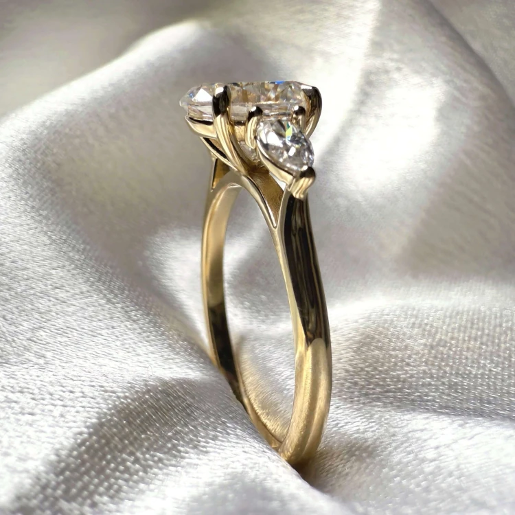 verlobungsring-trinity-seraphina-labordiamant-2ct-zentraler-stein-ovalschliff-nahaufnahme-seite-gelbgold-hariets.jpg