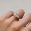 Verlobungsring-Trinity-Seraphina-labordiamant-2ct-ovalgeschliffener-Mittelstein-Seitenansicht-am-Finger-Gelbgold-Hariets.jpg