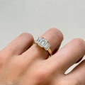 verlobungsring-trinity-moissanit-3ct-emeraldschliff-am-finger-seite-gelbgold-envy-hariets.jpg