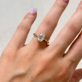 verlobungsring-mit-gedrehtem-ringband-moissanit-2ct-ovalschliff-am-finger-nahaufnahme-gelbgold-twisted-hariets.jpg