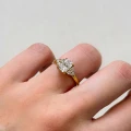 verlobungsring-trinity-moissanit-1ct-radiantschliff-am-finger-nahaufnahme-gelbgold-legacy-hariets.jpg