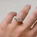 Verlobungsring-Trinity-Seraphina-Moissanit-2ct-ovalgeschliffener-Mittelstein-am-Finger-Gelbgold-Hariets.jpg