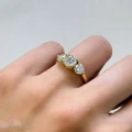 verlobungsring-trinity-moissanit-2ct-brillantschliff-am-finger-nahaufnahme-gelbgold-trigem-hariets.jpg