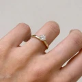 Verlobungsring-Solitaire-Bloom-Moissanit-0-6ct-Brillantschliff-Seitenansicht-am-Finger-Gelbgold-Hariets.jpg