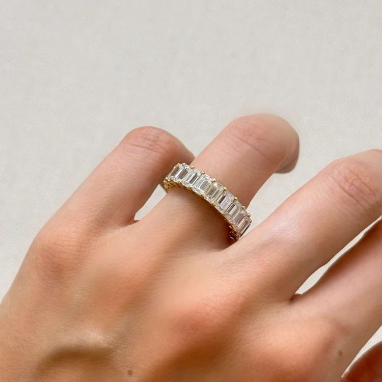 ehering-eternity-mit-moissaniten-smaragdschliff-am-finger-nahaufnahme-gelbgold-hariets.JPG