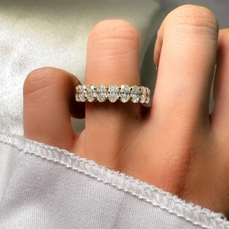 eternity-ring-mit-moissaniten-ovalschliff-am-finger-nahaufnahme-gelbgold-hariets.jpg