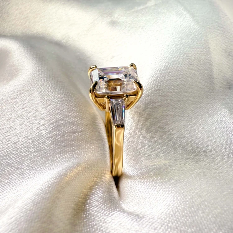 verlobungsring-trinity-moissanit-4ct-smaragdschliff-nahaufnahme-seite-gelbgold-florence-hariets.jpg